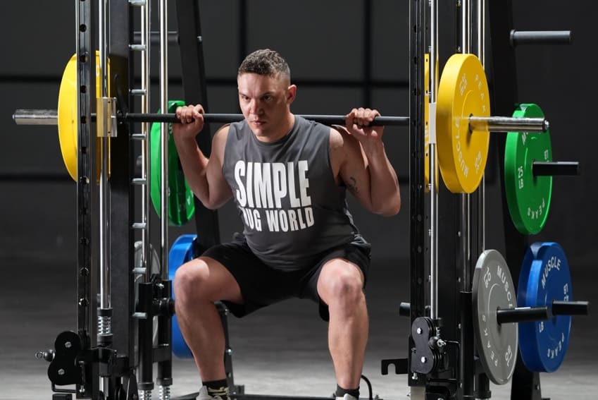 A man is lifting barbell on smith machine