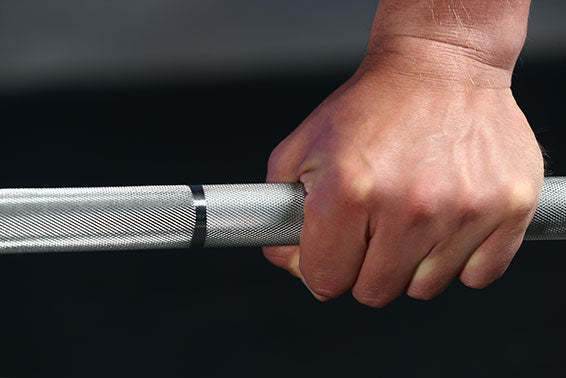 One hand is gripping the barbell bar.
