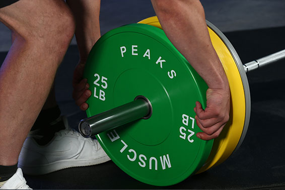 A man is turn off a barbell plate