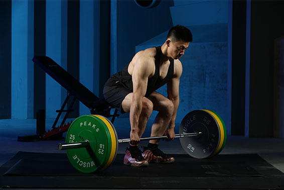 A man is trying to lift a barbell