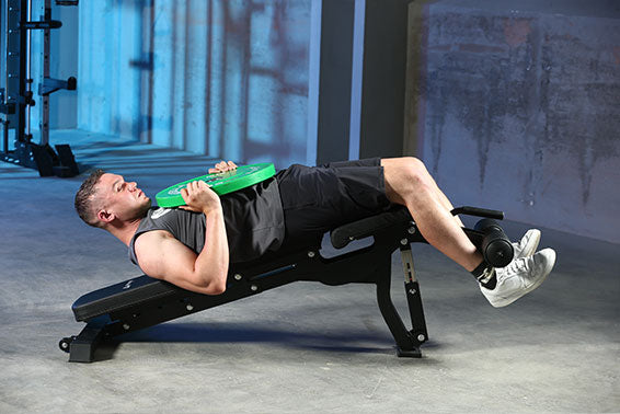 A man is doing Weighted Decline Sit-Up on the bench