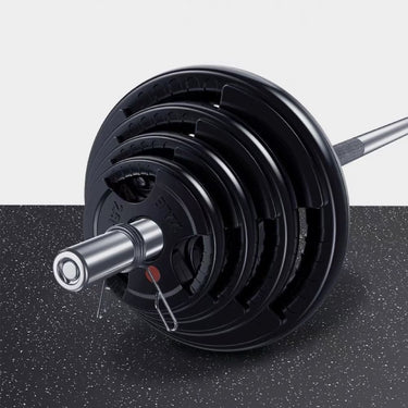 A black barbell pressed into a floor mat