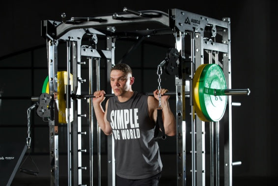 A man is lifting barbell on the smith machine