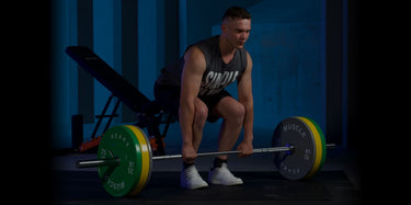 A man is trying to lift a barbell