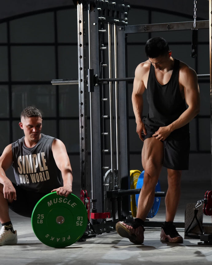 A man showing off his muscles in front of a black power rack